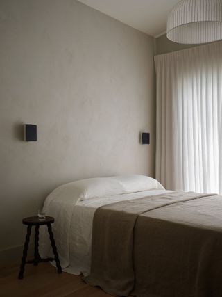 minimalist bedroom with limewash wall and becover