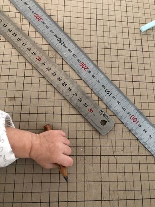 Rulers, baby holding pencil in hand