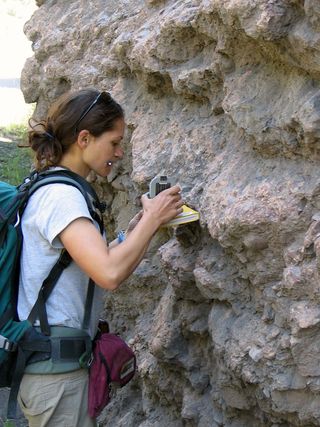 University of Michigan graduate student Alison Duvall measuring rock orientation. These rocks have been folded as a result of continental collision between India and Asia.