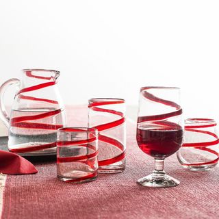 Red Ribbon Handmade Recycled Drinkware Collection on a red table runner. 