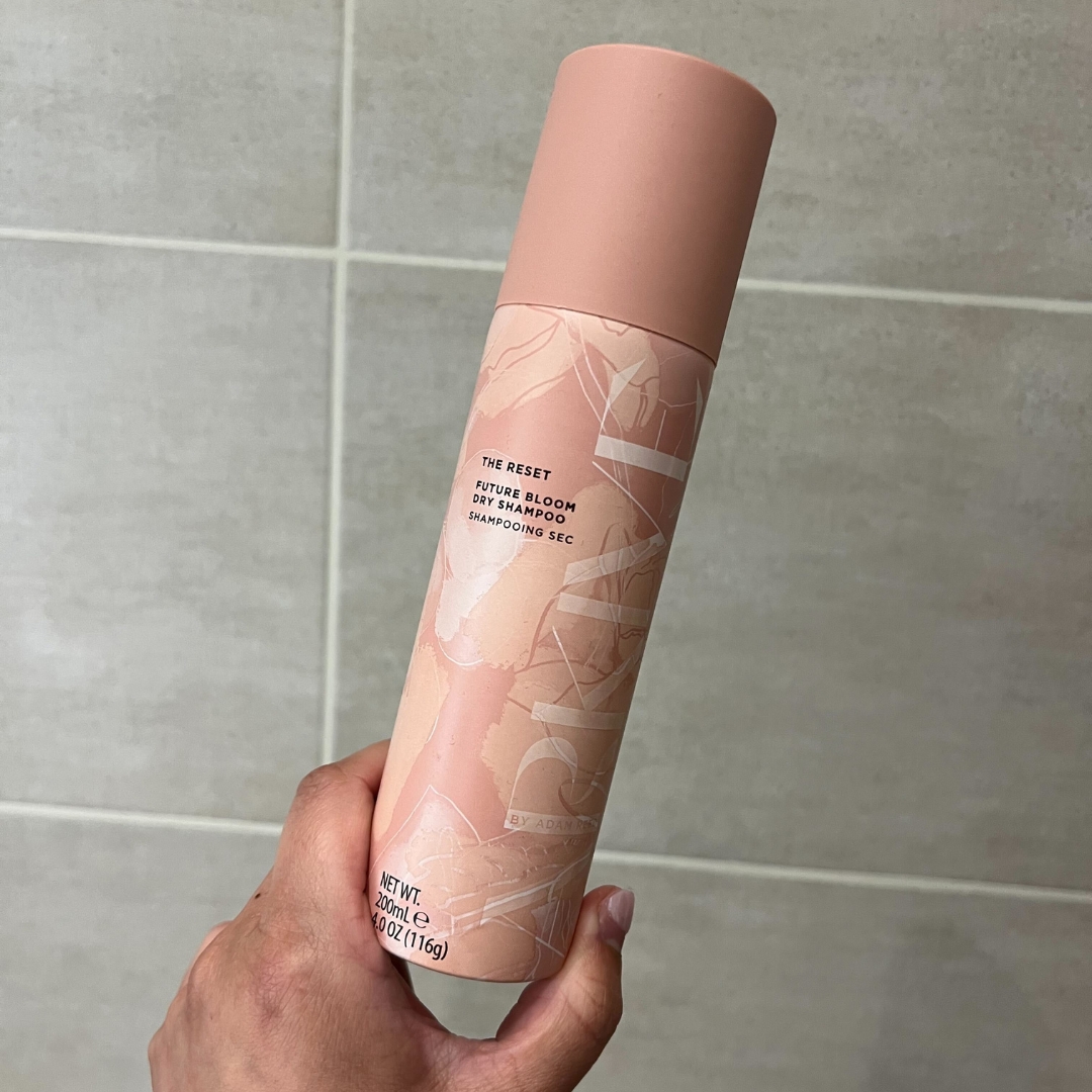 Hand holding pink bottle of Arkive The Reset Future Bloom Dry Shampoo