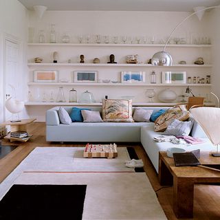 living room with blue sofa and wall shelving