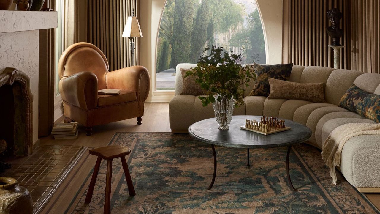 spanish vintage living room decorated with a boucle large curved couch and a tapestry inspired rug 