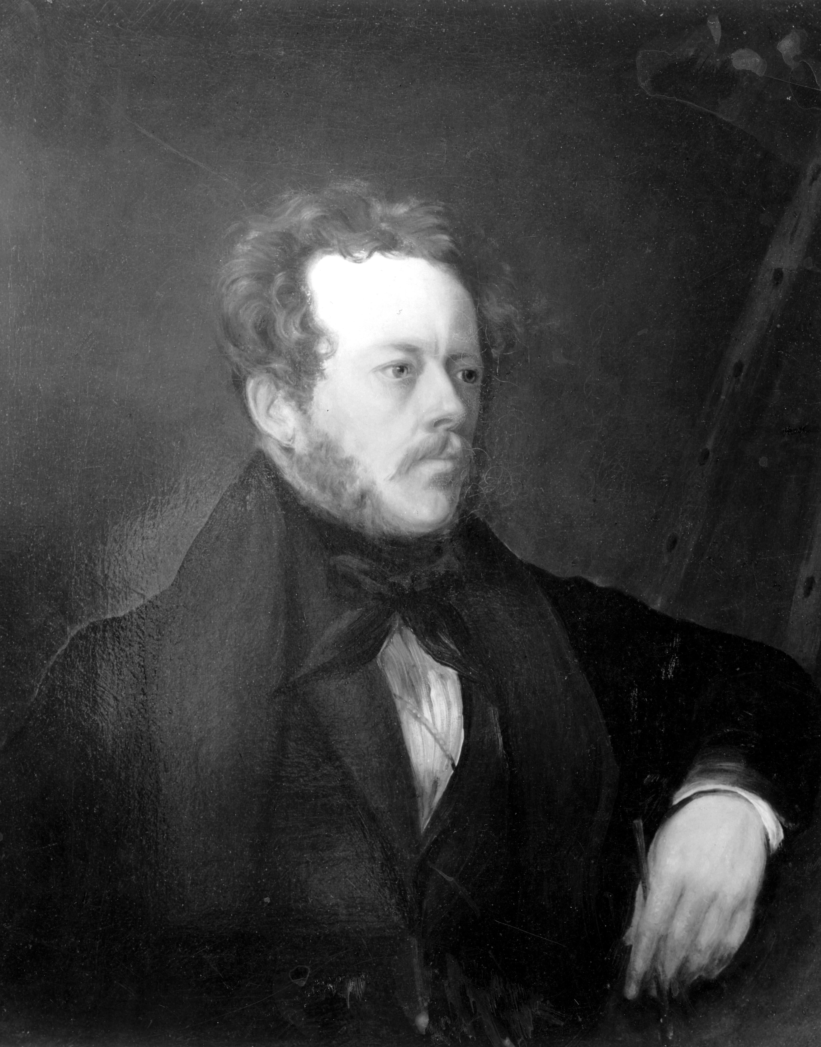 A black and white portrait of a pensive looking man