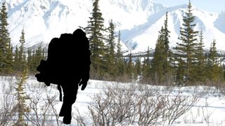 Silhouetted hiker in the snowy mountains