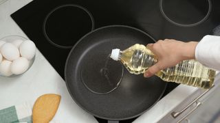 Oil being poured into a frying pan