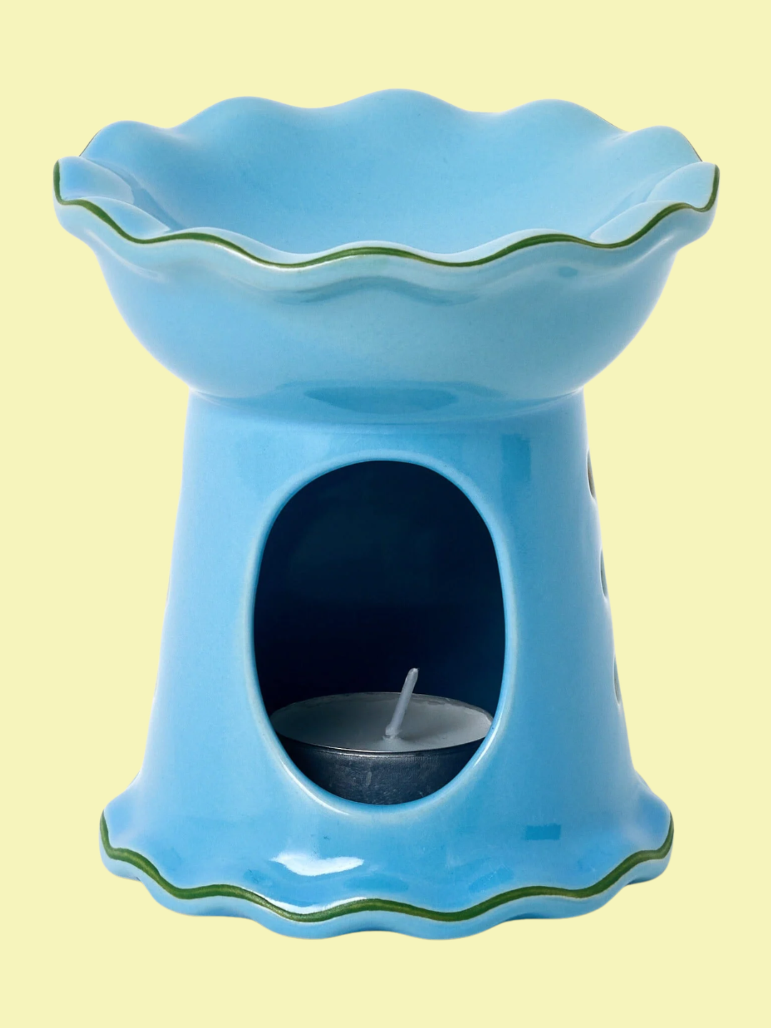 A blue ceramic oil burner with a ruffle top and a green hem