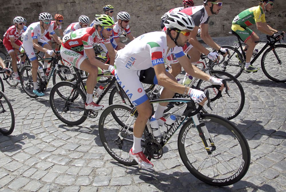 Riders tackle a cobbled climb