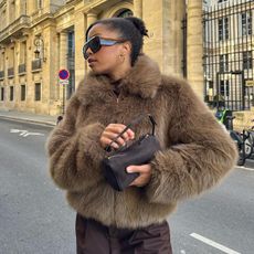 Woman wearing faux fur jacket and The Row '90s bag