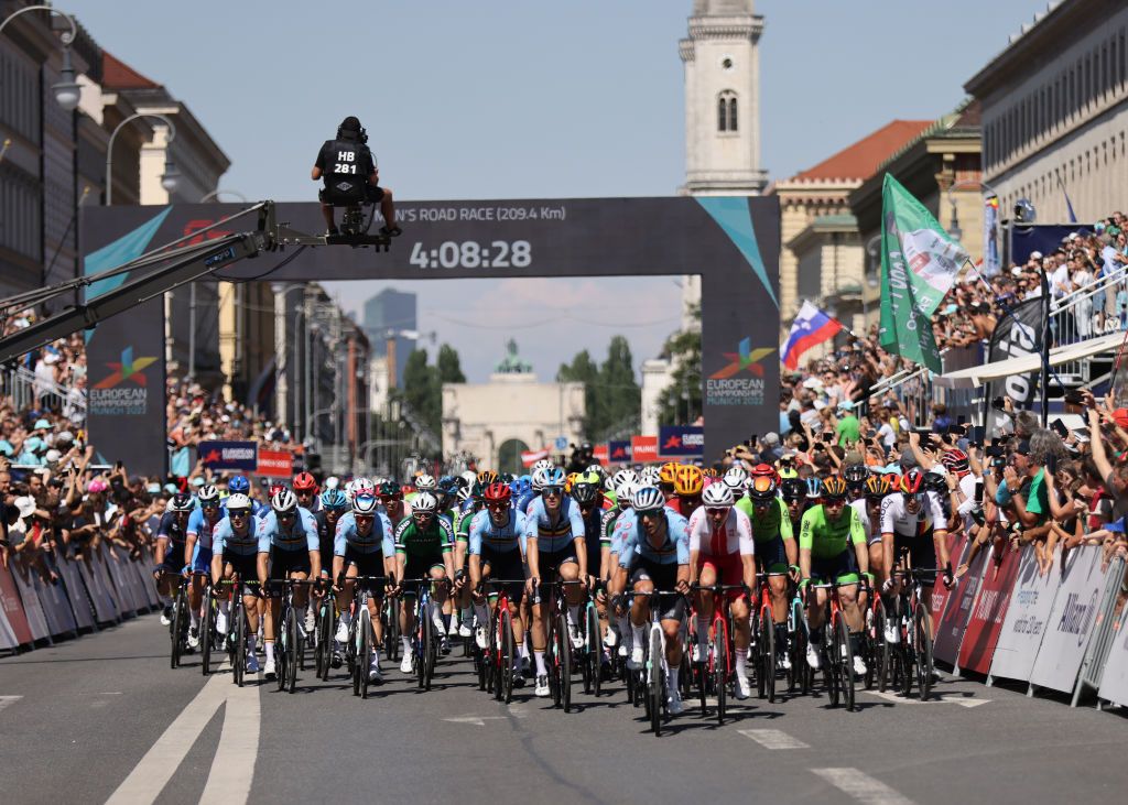 MUNICH GERMANY AUGUST 14 LR Bert Van Lerberghe of Belgium Tim Merlier of Belgium Dries De Bondt of Belgium Jan Tratnik of Slovenia Nils Politt of Germany and a general view of the peloton passing through Munich streets while fans cheer during the 28th UEC Road Cycling European Championships 2022 Mens Road Race a 2079km one day race from Murnau to Munich EuroRoad22 Munich2022 on August 14 2022 in Munich Germany Photo by Jan HetfleischGetty Images