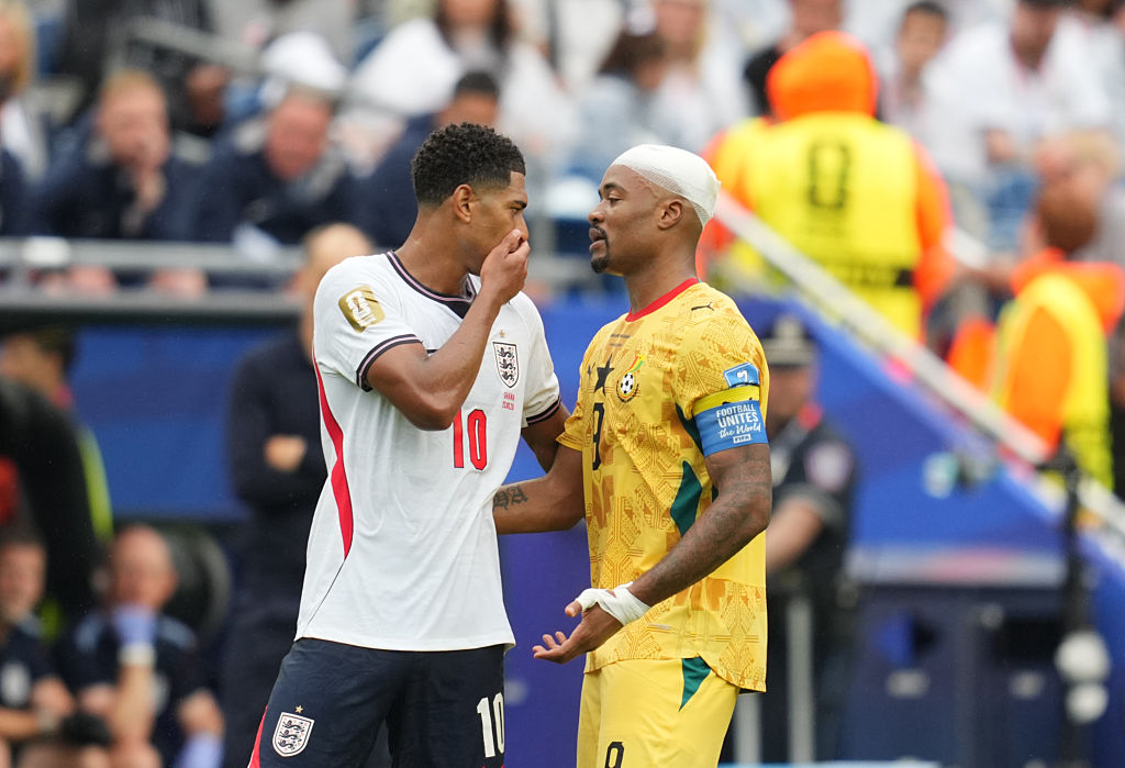 Jude Bellingham covered his mouth with his hand while talking to Jordan Ayew