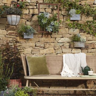 stone wall with pillow and kettle on sofa