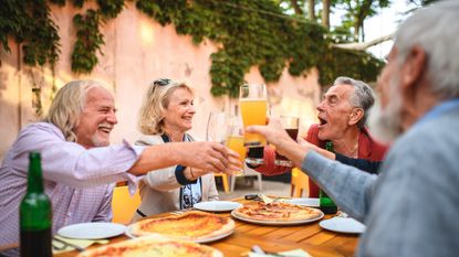 Two senior couples enjoying drinks at a restaurant.