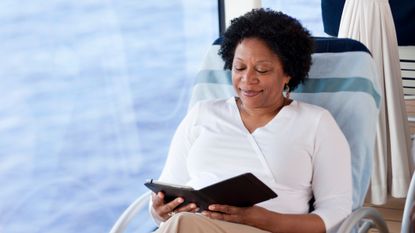 Woman sitting down reading a kindle ereader