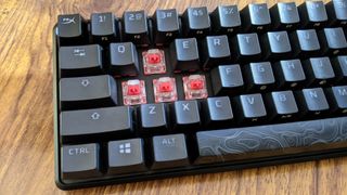 The W, A, S and D keycaps have been removed to reveal the red switches of the HyperX Alloy Origins 60