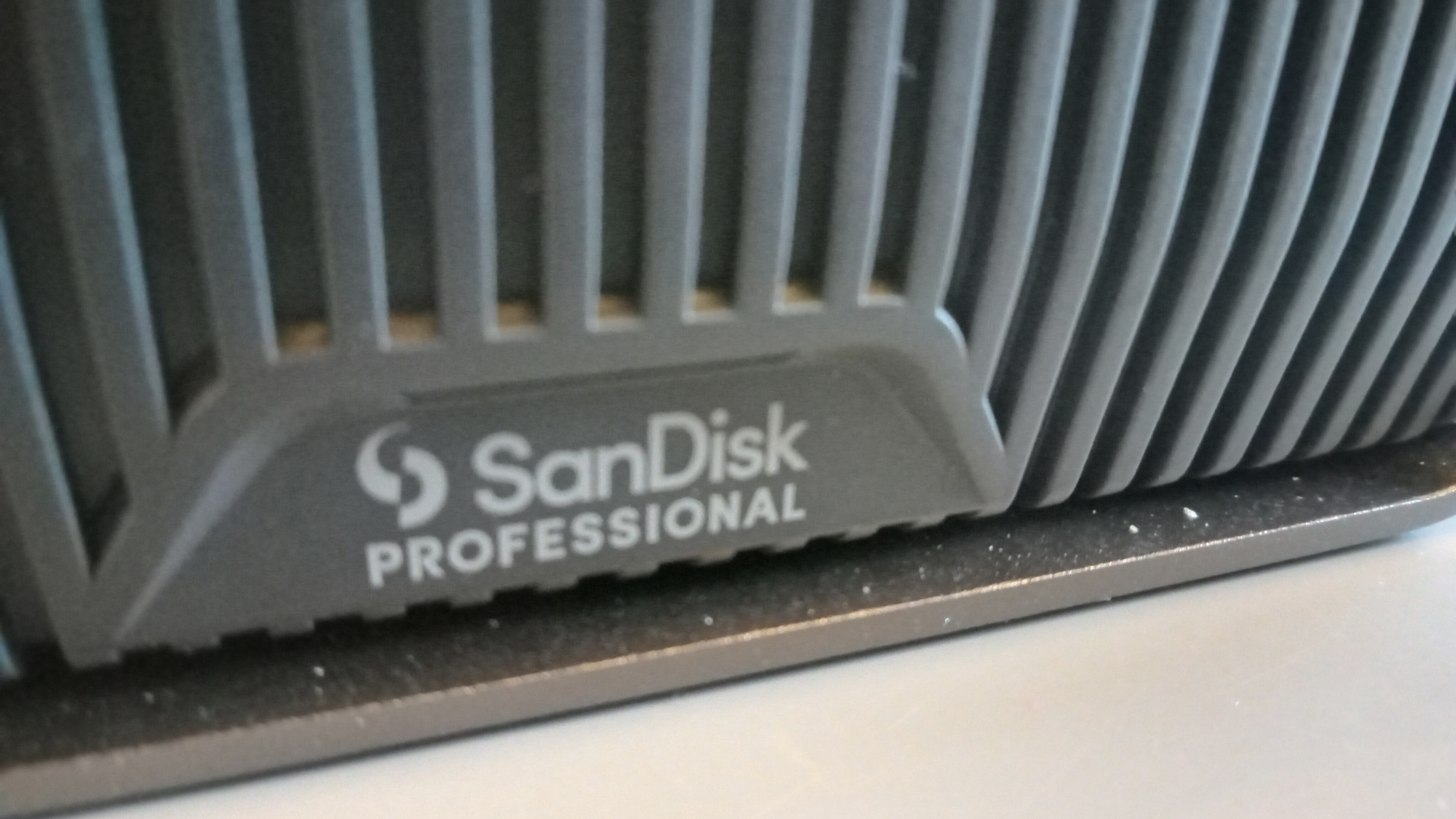 A grey aluminium SanDisk Professional G-Drive HDD on a table