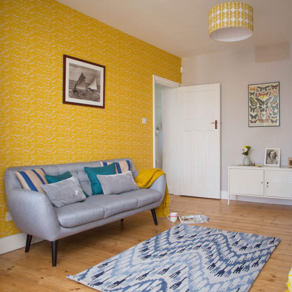 room with patterned wallpaper and wooden flooring