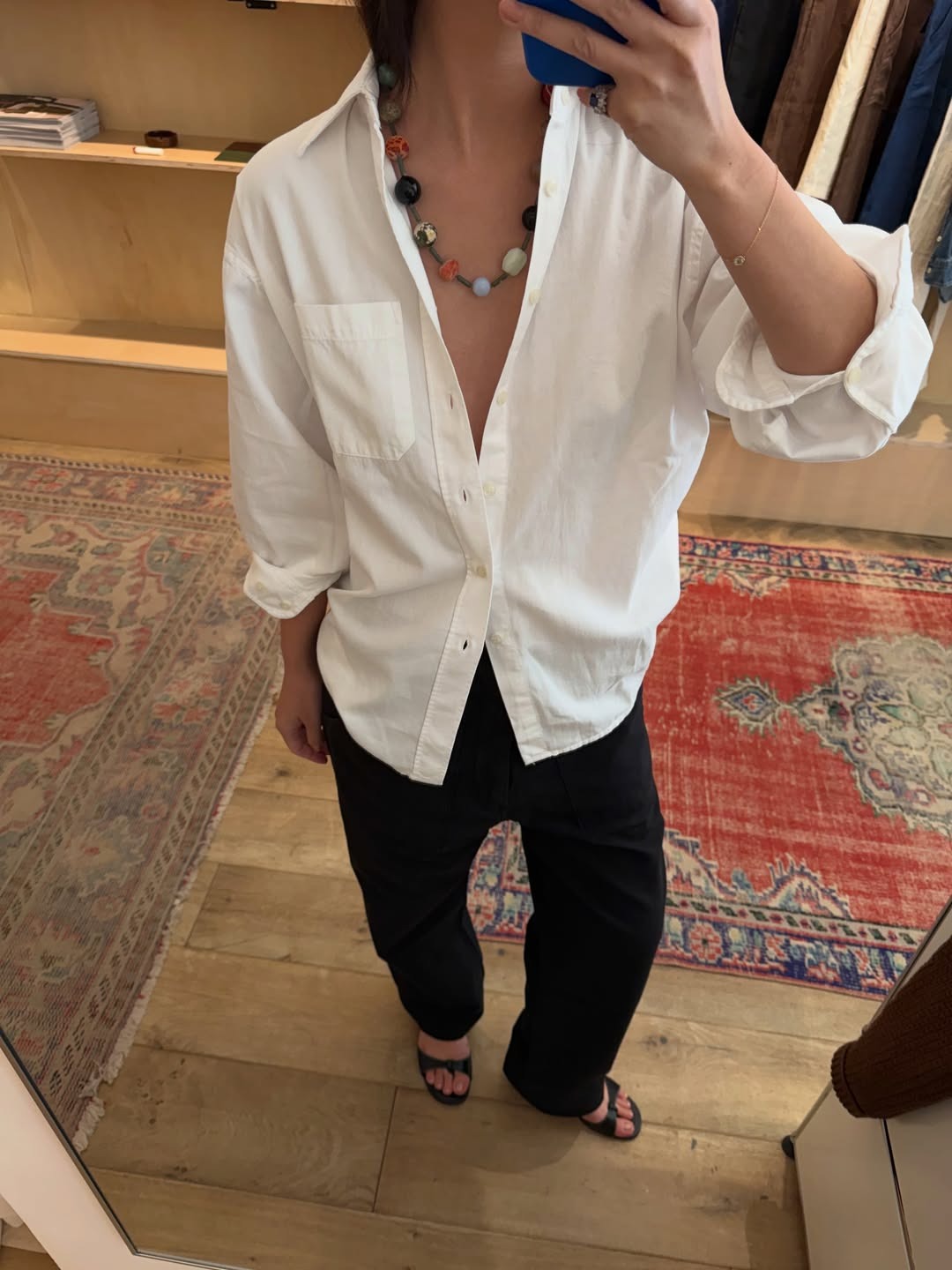 @mimixn wearing a white button down and black trousers with a beaded necklace