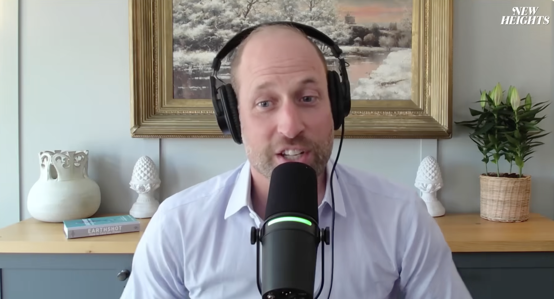 Prince William sitting in front of a mic and a painting