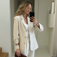 Woman wearing white best bodysuit with blazer and linen pants.