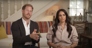 meghan markle and prince harry sit together in an on camera interview wearing a blush pink ralph lauren linen set