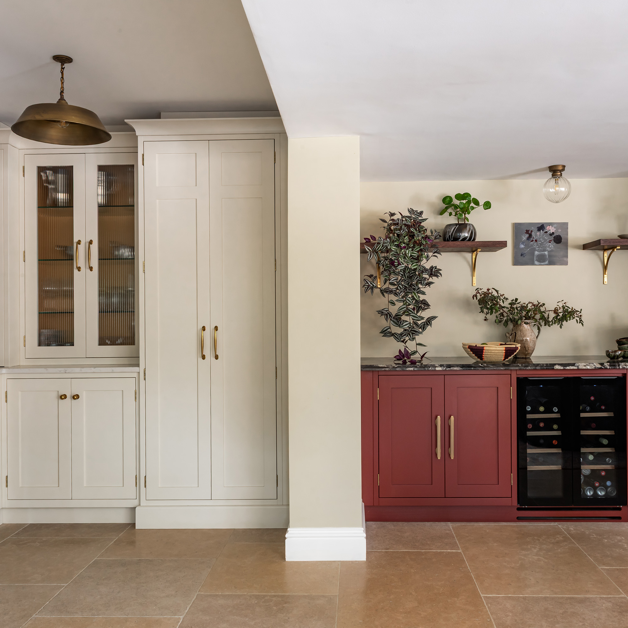 two zones in a kitchen with white cabinetry on pantry run and red cabinetry in utility run