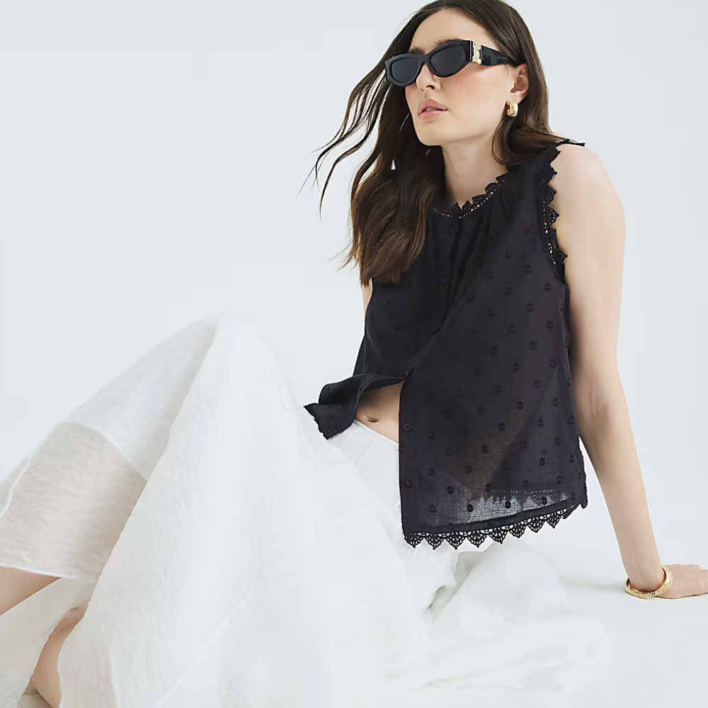 Woman wears black top and white skirt 