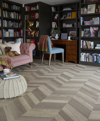 home office in living room with vinyl flooring and library of books
