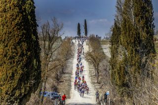 The peloton tackles a white gravel road during the 2022 Strade Bianche