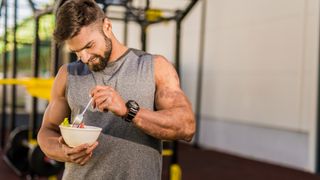 A man eating a healthy bowl of food at the gym