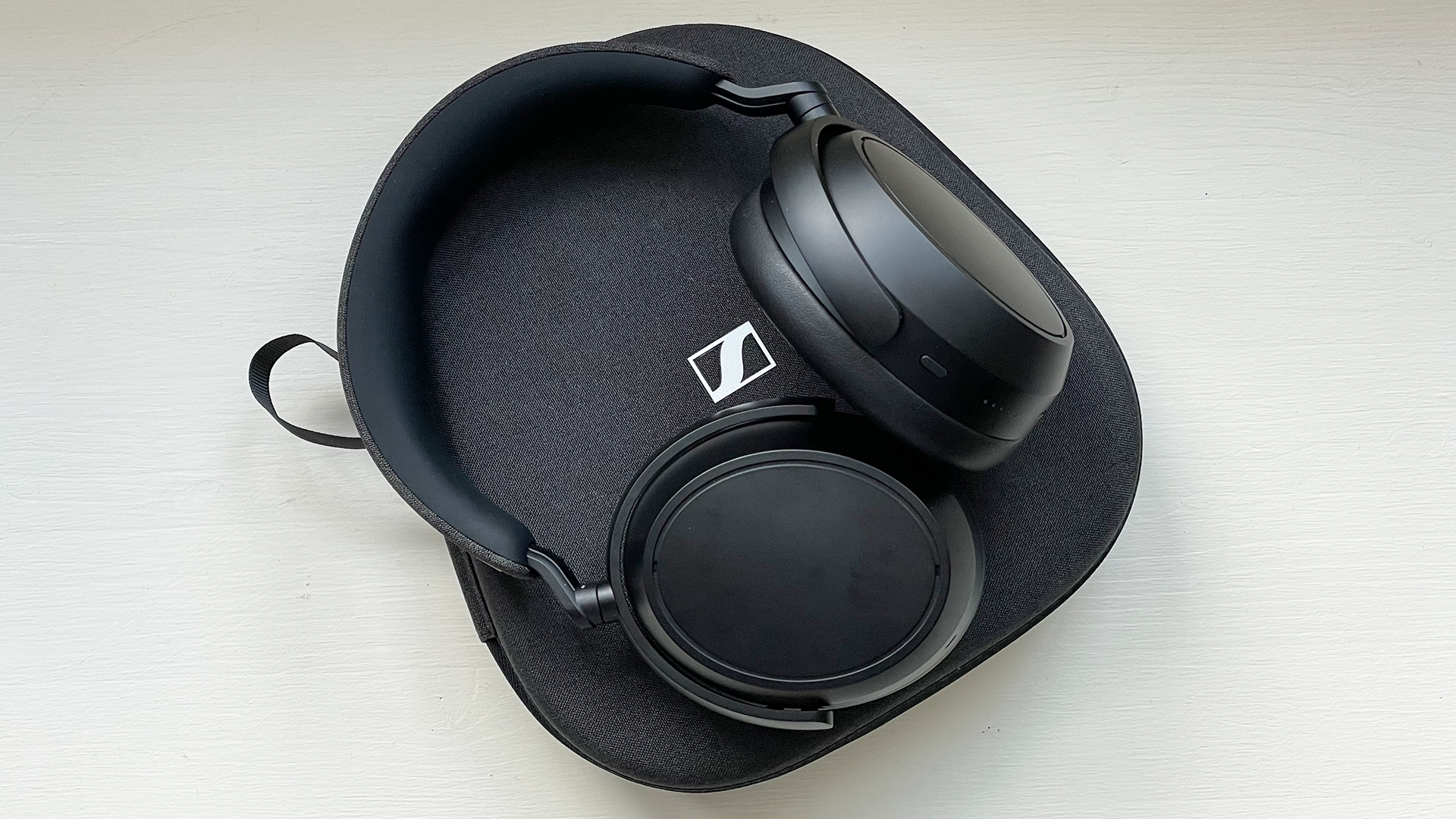 Sennheiser Momentum 4 wireless headphones case on the reviewer's window seat