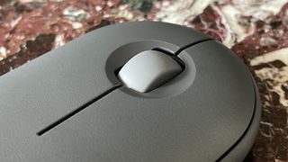 The middle mouse button and click wheel on the. top of the Logitech Pebble Mouse 2 M350S mouse.