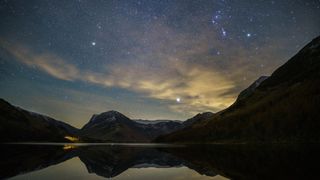 a band of bright stars above mountains and a clear lake