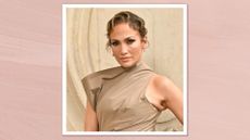 Jennifer Lopez wears an asymmetric brown dress with a curly updo hairstyle and a bronzed makeup look