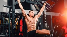 Man performing ab exercise hanging from bar