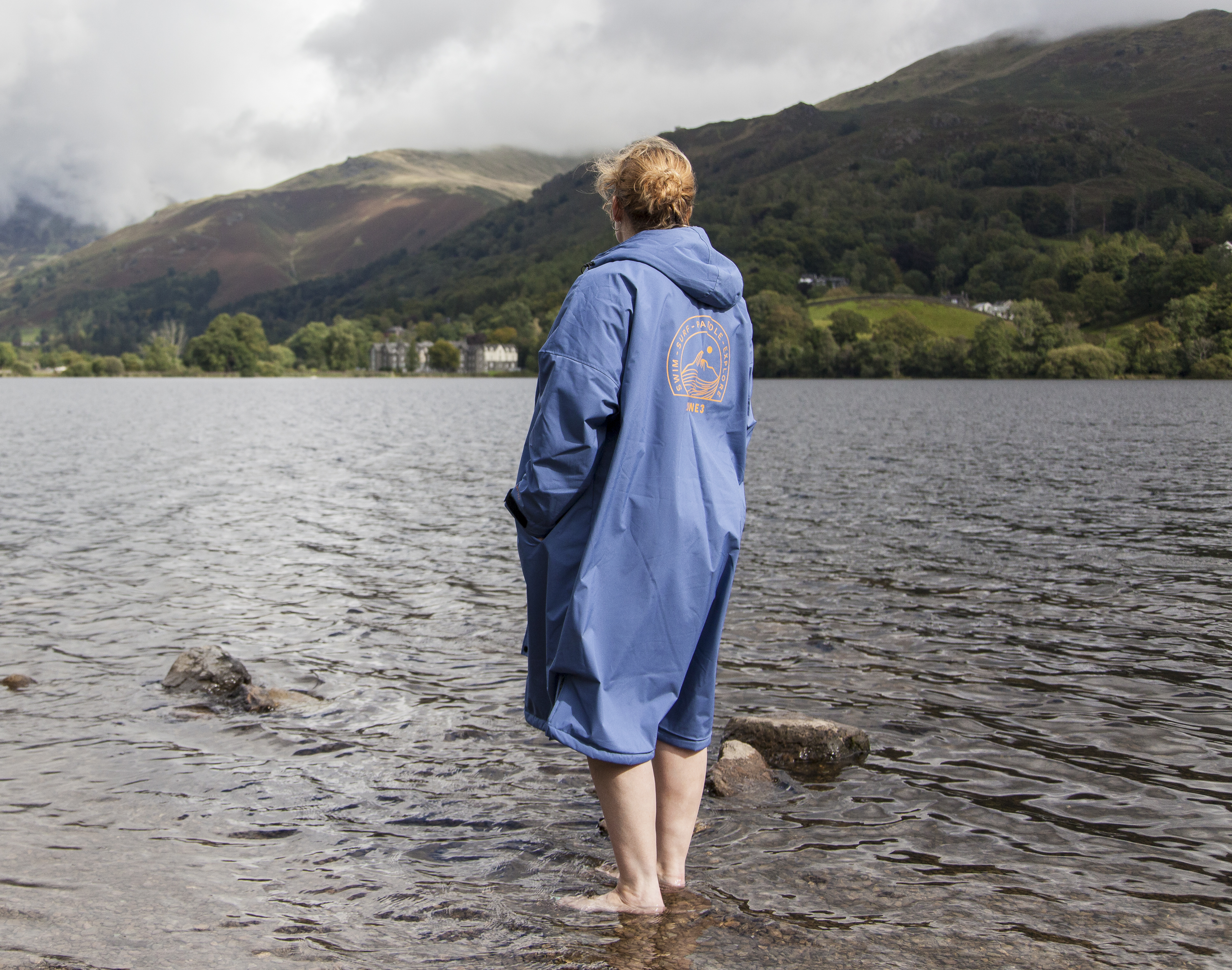 Woman standing in Grasmere lake wearing Zone3 thermotech changing robe