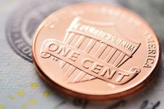 One cent US coin with dollar bill. 