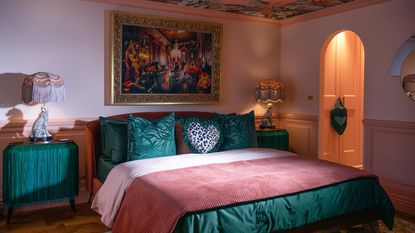 bedroom with statement wallpaper and blue velvet bed