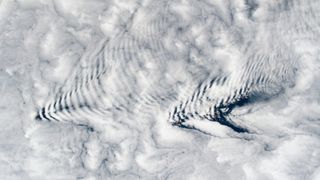 A pair of arrow-shape ripples in clouds as viewed from space