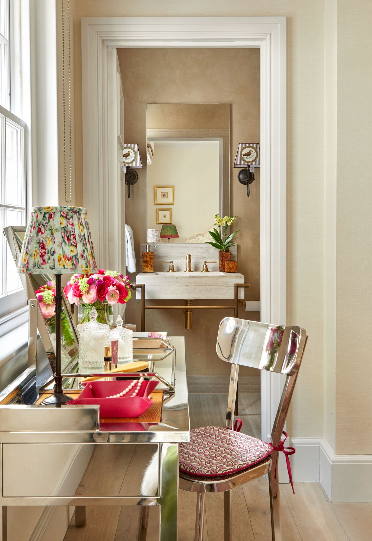 Reflective metal desk chair and desk, gold fixtures on stone sink