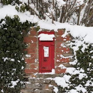 brick wall with red door and snow