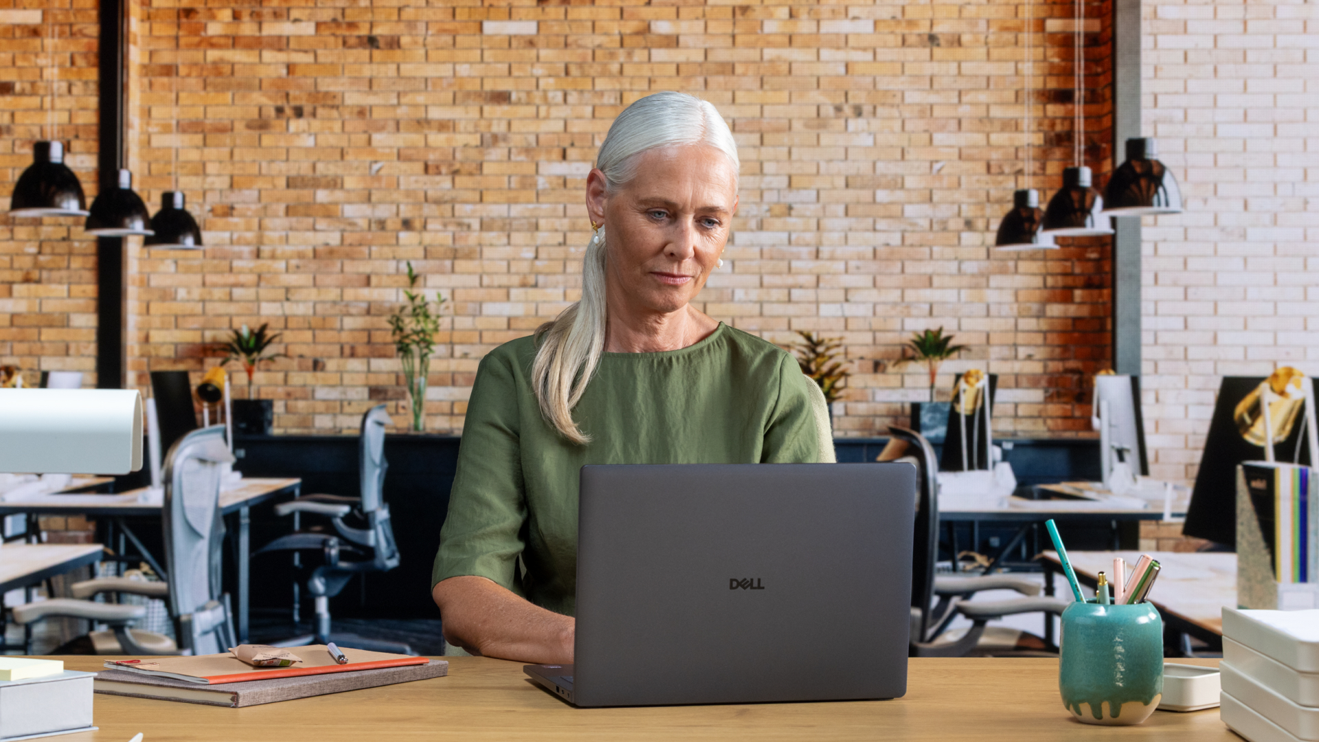 Dell Pro laptop being used by a person sat at a desk in an office