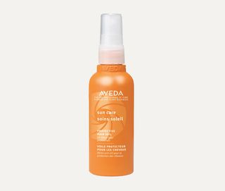 aveda sun care protective hair veil in orange bottle against grey background