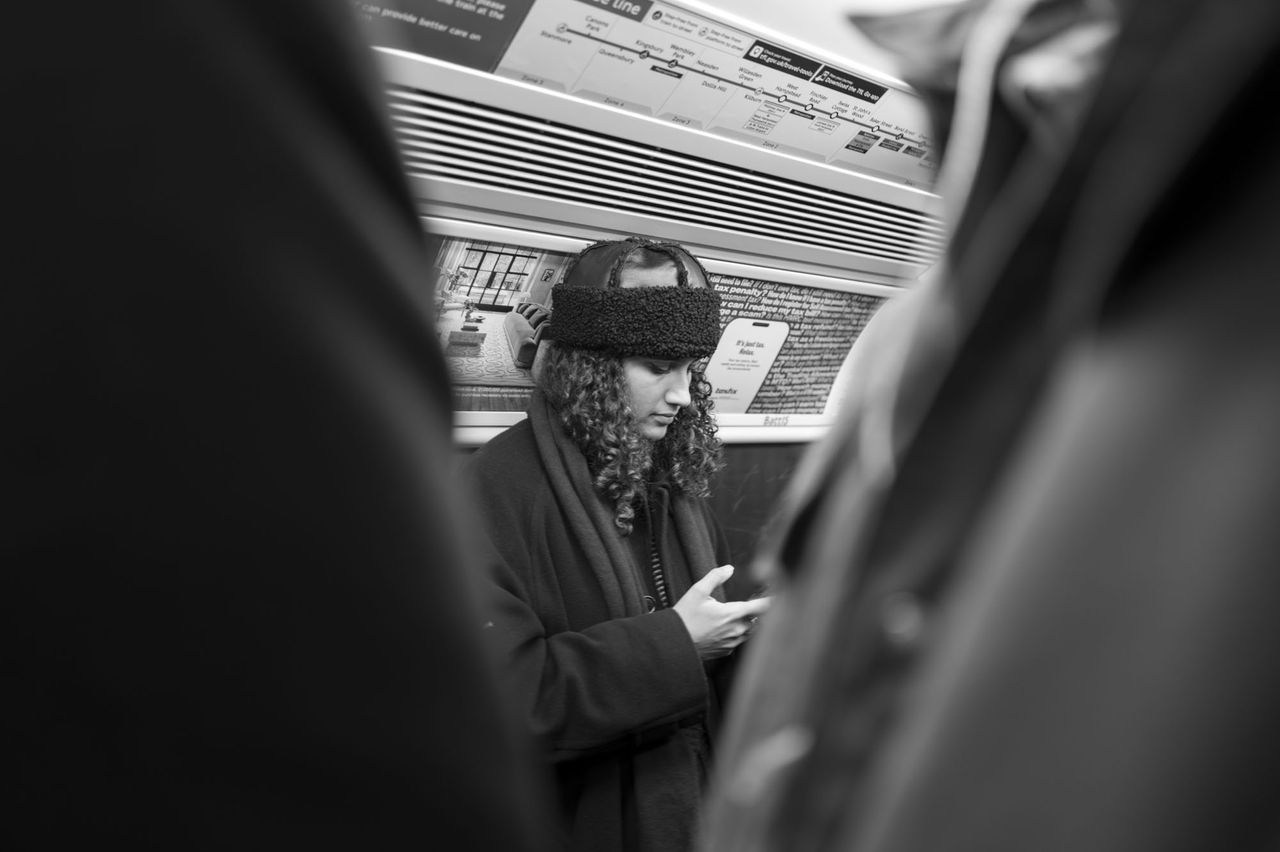 Leica Q3 Monochrom sample gallery: commuter on the underground looking at thier phone