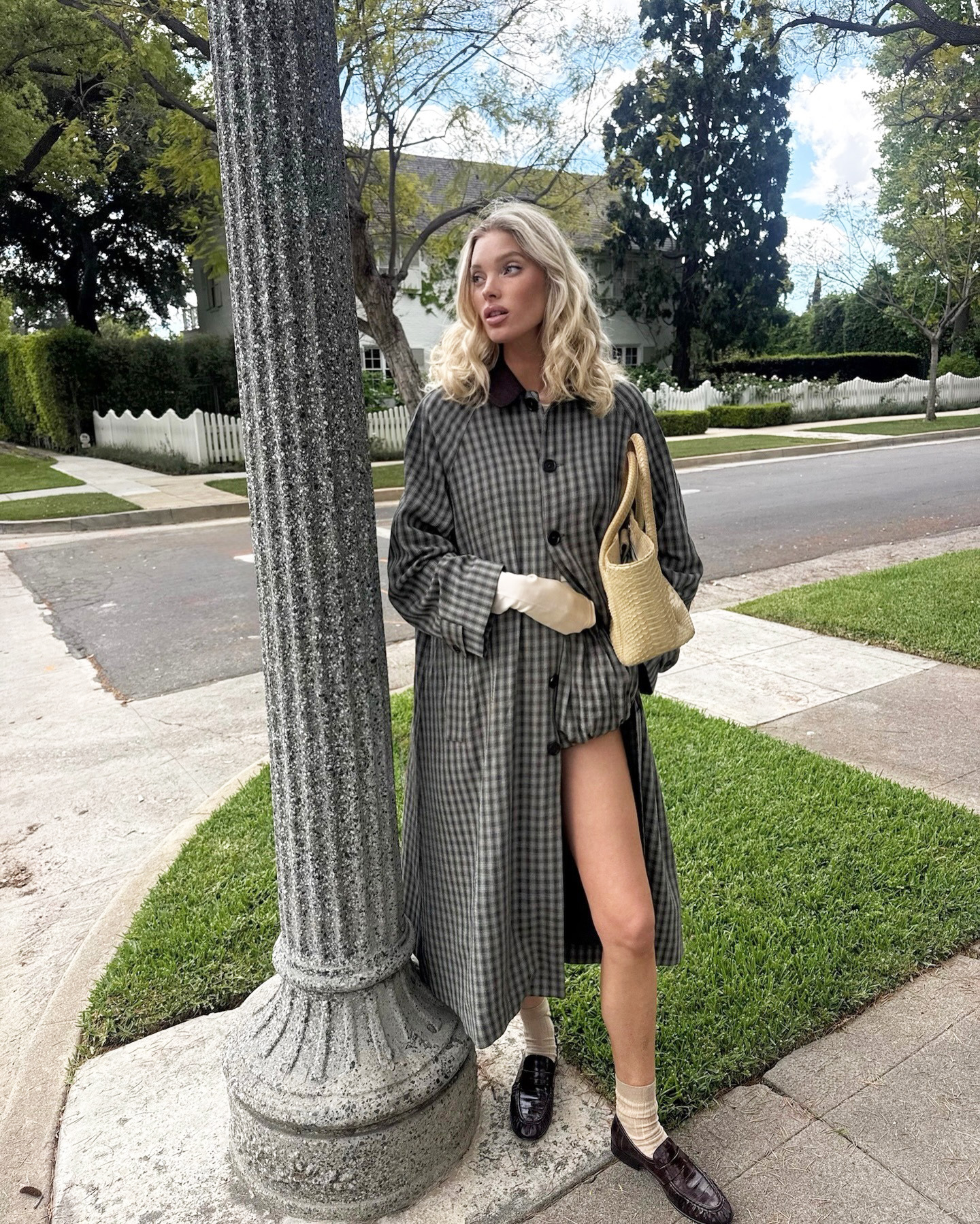 Elsa Hosk wearing a Helsa trench and shorts with a Chanel tote and Comme Si Yves Socks in Khaki
