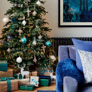 living room with blue sofa and christmas tree