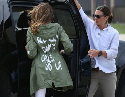 Melania Trump wears a green jacket that says, "I really don't care, do u?"