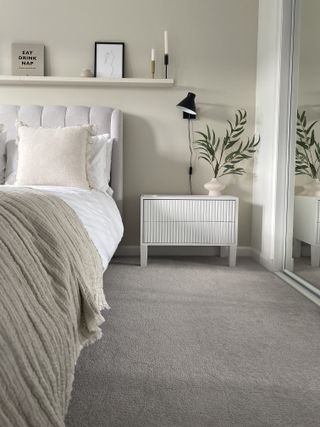 grey bedroom with white bedside table and plants