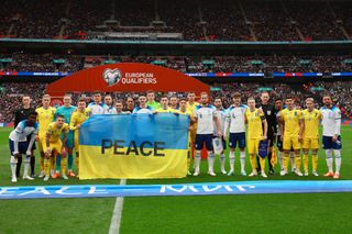 Players from both side's pose for a photograph with a Ukraine flag with the word Peace on prior to the UEFA EURO 2024 qualifying round group C match between England and Ukraine at Wembley Stadium on March 26, 2023 in London, England. (Photo by Eddie Keogh - The FA/The FA via Getty Images)