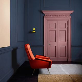 room with blue wall and pink door and arm chair wooden floor